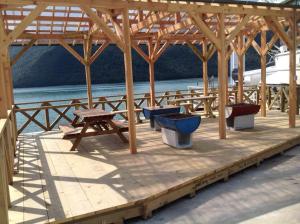 a wooden pavilion with benches and a picnic table at Costa Hinase Resort in Kakui-jima