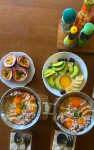 a table with three plates of breakfast food on it at A-Frame House บ้านเอเฟรม แดลอร์ปู in Ban Yang