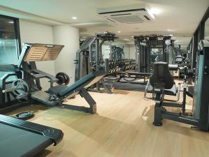 a gym with several tread machines in a room at Nusatu by ARTOTEL - Semarang in Semarang