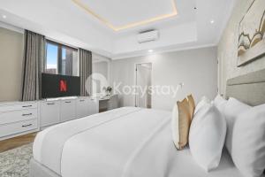 a white bedroom with a large bed and a tv at Rosen by Kozystay - Thamrin in Jakarta +46 photos