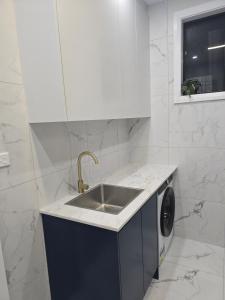 a kitchen with a sink and a washing machine at Simran's in Glenwood +40 photos