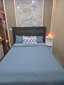 a bedroom with a bed with a blue comforter at Simran's in Glenwood