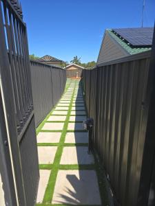 a fence with a long sidewalk next to a house at Simran's in Glenwood