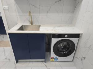 a kitchen with a sink and a washing machine at Simran's in Glenwood