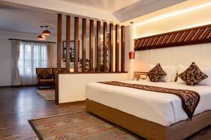 a bedroom with a large bed in a room at Maya Manor Boutique Hotel - A Restored Heritage Mansion in the Heart of Kathmandu in Kathmandu