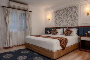 a bedroom with a large bed and a window at Maya Manor Boutique Hotel - A Restored Heritage Mansion in the Heart of Kathmandu in Kathmandu