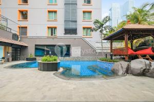 a swimming pool in front of a building at Rosen by Kozystay - Thamrin in Jakarta