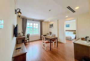 a living room with a table and a bedroom at Phoenix Hotel Vung Tau in Vung Tau