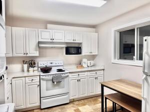 a kitchen with white cabinets and a white stove top oven at 2BR sweet suite in Nanaimo