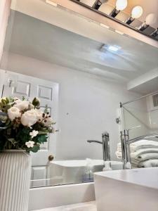 a bathroom with a vase of flowers on a counter at 2BR sweet suite in Nanaimo +30 photos