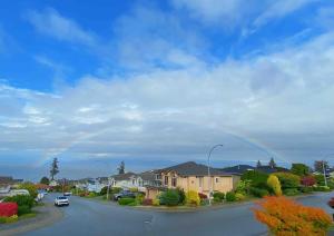 a rainbow in the sky over a street with houses at 2BR sweet suite in Nanaimo