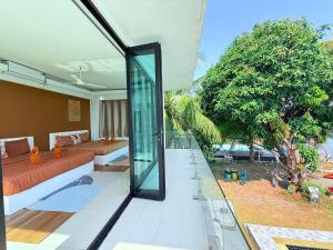 a living room with a couch and a glass wall at Koh Chang Pool Villa Viewthalay in Ko Chang +99 photos