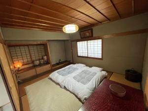 a bedroom with a large bed in a room at 丸亀 Sawai 一棟貸し 丸亀駅徒歩 10人まで宿泊可能 駐車場2台有 子供部屋ベビーベッド有 in Marugame