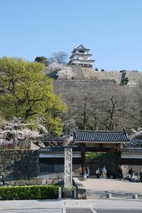 a park with a building on top of a hill at 丸亀 Sawai 一棟貸し 丸亀駅徒歩 10人まで宿泊可能 駐車場2台有 子供部屋ベビーベッド有 in Marugame