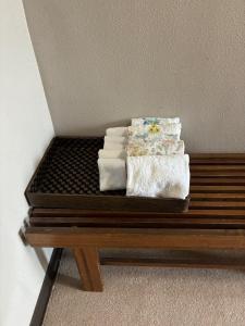 a pile of towels sitting on a wooden bench at 丸亀 Sawai 一棟貸し 丸亀駅徒歩 10人まで宿泊可能 駐車場2台有 子供部屋ベビーベッド有 in Marugame +57 photos