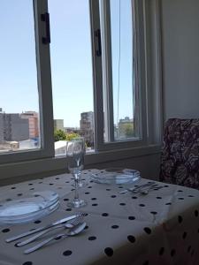 a table with plates and a wine glass on it at Apto completo centro in Rio Grande