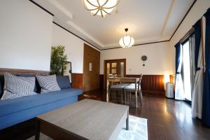 a living room with a blue couch and a table at Hideaway Hakone Sengokuhara in Sengokuhara