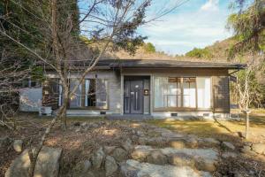 a small house in the mountains with a stone driveway at Hideaway Hakone Sengokuhara in Sengokuhara