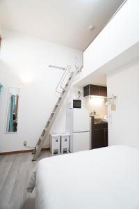 a white room with a kitchen and a staircase at Mary's Room Sumiyoshi in Sumiyoshi