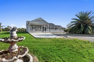 a fountain in front of a house with a building at Bloom by the Bend in Tooradin