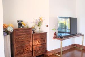 a dresser with a mirror and a dresser with flowers on it at Bloom by the Bend in Tooradin