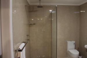 a bathroom with a glass shower with a toilet at Lure Bed and Breakfast in Normanville