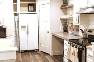 a kitchen with white cabinets and a white refrigerator at The Gate City Grande in Pocatello