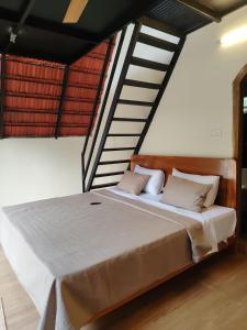 a bedroom with a large bed with a staircase at Arundekar's Cottage in Gokarna