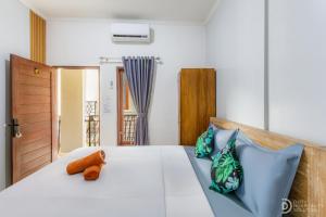 a bedroom with a white bed with blue pillows at Bali DD homestay seminyak in Seminyak +85 photos