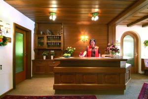 a woman is standing behind a counter in a room at Hotel Garni Val-Sinestra in Ischgl
