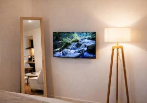 a room with a television on the wall and a lamp at Spacious & Luxuary Studio in Amiens