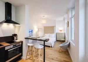 a room with a bed and a kitchen with a table at Spacious & Luxuary Studio in Amiens