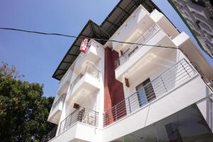 a white building with a red wall at Pearl Suites in Cochin