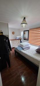 a bedroom with a large bed and a chandelier at Maitencillo Shelter in Puchuncaví