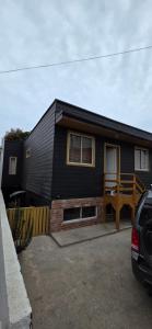 a black house with a car parked in front of it at Maitencillo Shelter in Puchuncaví +10 photos
