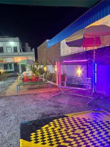 a stage with an umbrella and benches in front of a building at Shiv Shakti Hotel And Resort in Mākundgarh