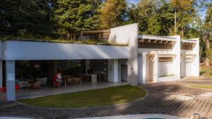 a white house with a patio and a yard at The Town at Praia in Jacó