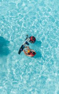two people are in the water in a pool at Villaasa in Shaviyani Atoll