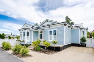 a blue house with a white fence at Britannia Villa in Greytown