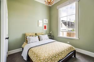 a bedroom with a bed and a window at Britannia Villa in Greytown