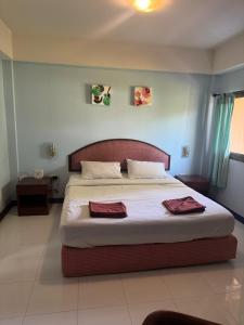 a bedroom with a large bed with two towels on it at Skippers beach guesthouse in Hua Hin +19 photos