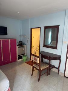 a room with a desk and a table and a mirror at Skippers beach guesthouse in Hua Hin