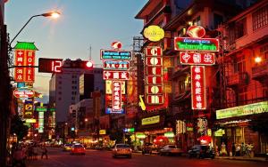 a busy city street with lots of neon signs at Merge Hostel in Samphanthawong