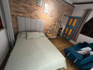 a bedroom with a large bed and a blue chair at Mirador De Las Pirámides in Zetaquira