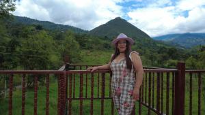 a woman in a hat standing on a fence at Mirador De Las Pirámides in Zetaquira