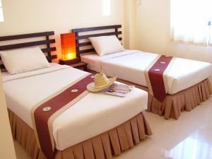 a bedroom with two beds with hats on top of them at River Resort & Spa in Sa Kaeo