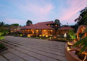 a large house with a courtyard in front of it at Punarjeevani Ayurvedic Heritage in Vythiri