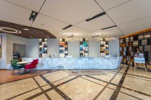 a lobby with a counter and chairs and a table at Ramada Encore by Wyndham Rajbagh Srinagar in Srinagar