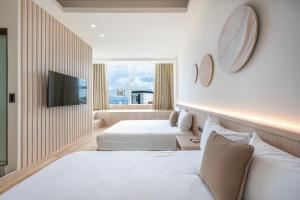 a hotel room with two beds and a flat screen tv at SMilE WAVE in Xiaoliuqiu