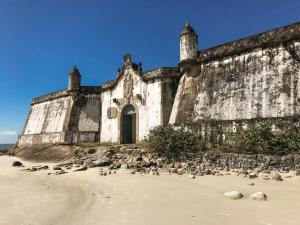 an old building on the beach with birds around it at KitNet a caminho da ILHA DO MEL in Pontal do Paraná
